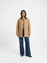 Campera estilo cargo color tostado, de corte recto y largo medio, con cuello camisero de pana marrón oscuro, cierre frontal con botones a presión y múltiples bolsillos frontales con solapa.