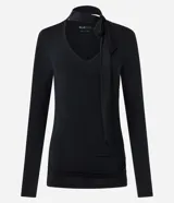 Blusa entallada de microfibra color blanco, con escote en V, mangas largas y detalle de frunces en los laterales. Presenta un lazo integrado en el cuello que permite anudarlo, aportando un toque sofisticado al diseño.