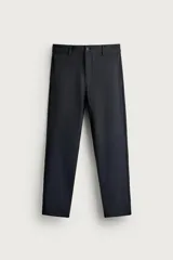 Pantalón chino negro de corte slim fit, confeccionado con tejido elástico en ambas direcciones. Cuenta con bolsillos frontales, bolsillos traseros de vivo con botón y cierre frontal con cremallera y botón.
