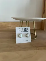 Aros tipo botón con perlas de río engarzadas en metal plateado.