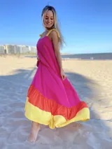 Vestido largo de tirantes color fucsia con volados en el ruedo en amarillo y naranja.