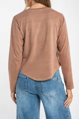 Remera de algodón lavado con corte oversize, cuello redondo y mangas largas.