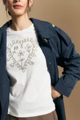 Remera de manga corta color marrón, con estampado central de corazón en color lila.