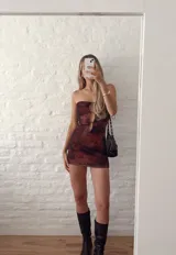 Vestido corto marrón con estampado animal print, corte ajustado, escote strapless con aberturas en el frente y breteles finos.