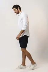 Camisa de vestir de manga larga en color blanco, con cuello clásico y cierre frontal de botones.