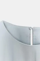 Vestido midi de Zara Woman Collection confeccionado en hilatura de algodón color celeste, con cuello redondo, manga corta y detalles de pliegues en la cintura. Presenta falda en línea evasé y cierre en la espalda con abertura y botón.