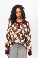 Buzo de tejido de punto con diseño estampado geométrico retro, cuello tipo polo con cierre frontal de botones y mangas largas con puños acanalados en color bordó.