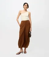 Pantalón de sastrería modelo aladim color marrón, con cintura recta, piernas amplias y ruedo ajustado. Confeccionado en tejido fluido de viscosa y poliéster.