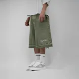 Bermuda de jean verde militar, corte ancho, con diseño de desgaste y flecos en el ruedo, y bordado con la inscripción 'Veneti Club'.