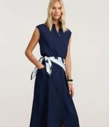 Vestido chemise midi azul marino de Marfinno, confeccionado en mezcla de lino y viscosa. Presenta cierre frontal de botones, cuello camisero, sin mangas y bolsillos laterales.