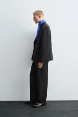 Pantalón de traje corte straight fit confeccionado en tejido mezcla de lana. Presenta cierre frontal con cremallera y botón, bolsillos laterales y bolsillos traseros de vivo.