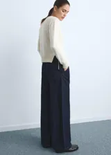 Pantalón de jean estilo wideleg de tiro medio, con pinzas delanteras, cierre de botón y cremallera, y cuatro bolsillos.