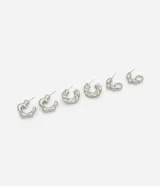 Set de tres pares de aros plateados con diferentes diseños: aros pequeños con forma de flor, aros medianos con forma trenzada y aros pequeños con forma de gota.