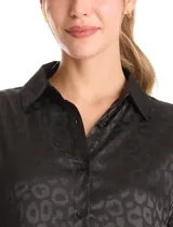 Camisa de satén marca Liv Los Angeles, con cuello clásico, cierre frontal con botones y mangas largas. Presenta un estampado animal print sutil en tono sobre tono.