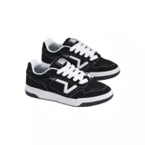 Championes Vans modelo Upland, de diseño urbano con estética skate. Presentan una base de gamuza negra con costuras blancas en contraste y el logo lateral característico de la marca en color blanco. Cuentan con suela de goma blanca y cordones al tono.