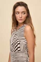 Vestido corto sin mangas de color celeste con estampado botánico en tonos marrones, de silueta amplia, escote redondo y volado en el ruedo.