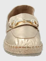 Alpargatas tipo slip-on en cuero metalizado color dorado, con detalle de herraje metálico en el empeine y suela con borde de yute trenzado.