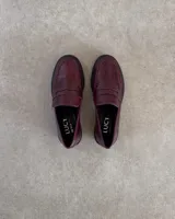 Mocasines color borgoña con textura símil piel de cocodrilo y suela track negra.