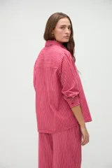 Camisa de manga larga de algodón, con diseño a rayas en tonos azules y morados, calce holgado, cuello camisero, cierre frontal con botones y un bolsillo aplicado en el pecho.