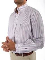 Camisa de corte clásico confeccionada en algodón, con diseño de rayas verticales finas en color rosa sobre fondo blanco. Presenta cuello abotonado, cierre frontal con botones, mangas largas con puños abotonados y un bolsillo en el pecho con el logo de la marca bordado.