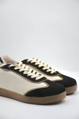 Zapatillas urbanas de cuero color beige y blanco con detalles en animal print en el talón y cordones marrones.
