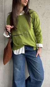 Sweater de punto color verde lima, de manga larga, con detalle de bordado en relieve con diseño floral en el frente.