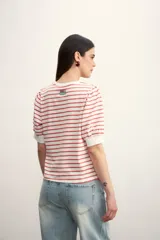 Remera de algodón con estampado de rayas horizontales en color verde claro sobre fondo blanco, con mangas cortas abullonadas y puños lisos.