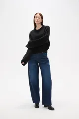 Sweater de tejido de punto color negro, con cuello redondo a la base, mangas largas y diseño holgado.