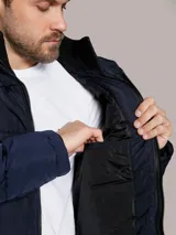 Campera puffer azul marino de Calvin Klein, de diseño acolchado con cuello alto y cierre frontal de cremallera. Incluye bolsillos laterales con cierre y chaleco interior desmontable.