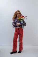 Pantalón de vestir de tiro alto, color rojo con estampado de flores grandes en tono marrón oscuro. Diseño recto con cordones ajustables en la cintura.