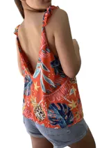 Musculosa estampada color naranja con hojas y flores en tonos azules, amarillos y celestes. Tiene breteles anchos con volados.