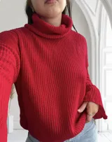 Sweater rojo de tejido de punto grueso con cuello alto y mangas largas.
