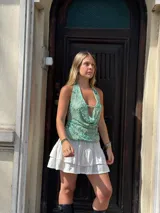 Top verde agua con escote drapeado, espalda descubierta y bordado de flores azules y lentejuelas.