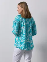 Blusa de gasa estampada marca Zac & Rachel. Tiene cuello a la base, escote en V con apertura y botones. Las mangas son 3/4 con frunce. Tiene detalle de crochet en hombros y delantera.