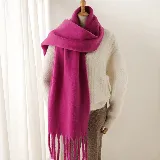Bufanda de tejido suave y abrigado en color fucsia, con diseño de flecos largos en los extremos.