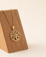 Collar de bronce dorado con cadena fina y dije circular colgante con diseño del árbol de la vida rodeado de incrustaciones de pedrería.
