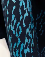 Túnica negra de gabardina de lana con estampado artesanal en tonos ocres. Cuenta con cuello mao, bolsillos laterales y dos piezas a modo de bufandas que se pueden anudar de diferentes maneras.