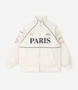 Campera bomber de microfibra color beige con estampado frontal de lettering 'PARIS 1985'. Presenta cierre frontal con cremallera, cuello alto, bolsillos funcionales y puños y ruedo ajustados con elástico.