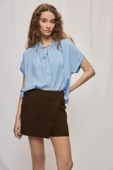Short cruzado de tiro medio color marrón, con diseño tipo falda en el frente y líneas simples.