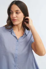 Camisa celeste de manga corta con cuello camisero y abotonadura frontal.