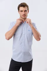 Camisa de manga corta a rayas celestes y blancas, con cuello abotonado, bolsillo frontal con logo bordado y cierre frontal de botones.
