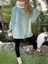 Polerón celeste de peluche con cuello alto y puños blancos.