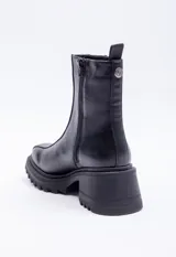 Bota marrón de símil cuero, caña media, punta redonda y plataforma tipo tractor color negro.