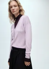 Cardigan de punto con cuello en pico y cierre frontal de botones. Presenta un diseño recto de manga larga con puños en contraste.