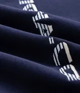 Buzo de corte boxy con cuello redondo y mangas largas raglán. Presenta un diseño bicolor en azul marino y gris, con detalles de piping en contraste y lettering bordado en el pecho.