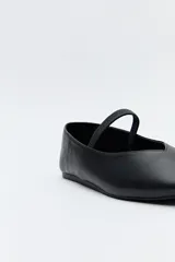 Balerina negra de cuero sintético con punta redondeada, escote en V y tira elástica sobre el empeine.