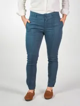 Pantalón chupín de gabardina elastizada color azul petróleo, tiro alto, con alforzas en delantero y trasero, pretina ancha con doble botón, bolsillos traseros falsos y terminación de bajo con puño y botón.