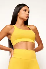 Top deportivo de alto rendimiento con diseño de espalda nadador, confeccionado en tejido técnico con protección UV50+. Presenta un bolsillo interno en el forro frontal y detalles reflectivos.