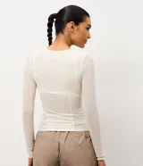 Remera deportiva de manga larga y cuello redondo, confeccionada en microfibra de poliamida con elastano, de diseño ajustado y corte entallado, con detalles en tul.