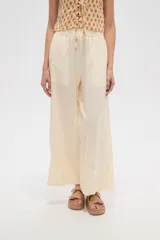 Pantalon de corte recto y tiro alto, confeccionado en viscosa de color natural, con cintura elástica y cordón ajustable.